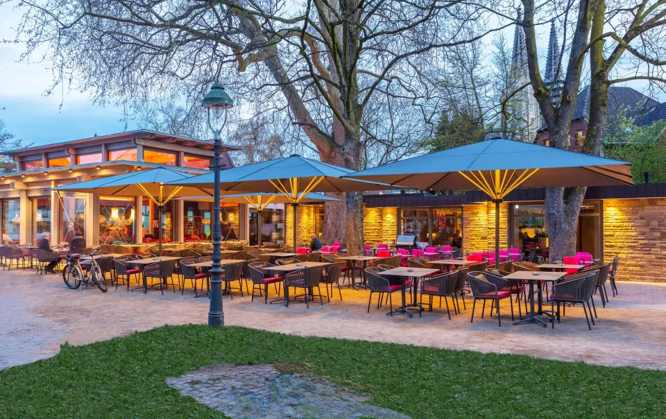 Großschirme über einem Biergarten am Abend