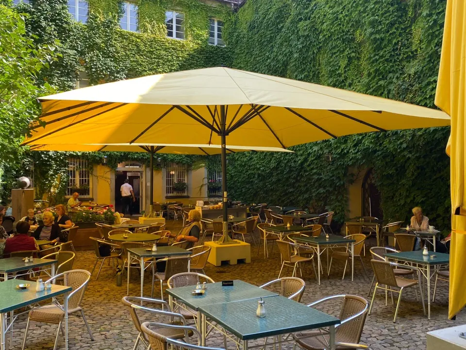 Gelbe Großschirme in einem grünen Innenhof