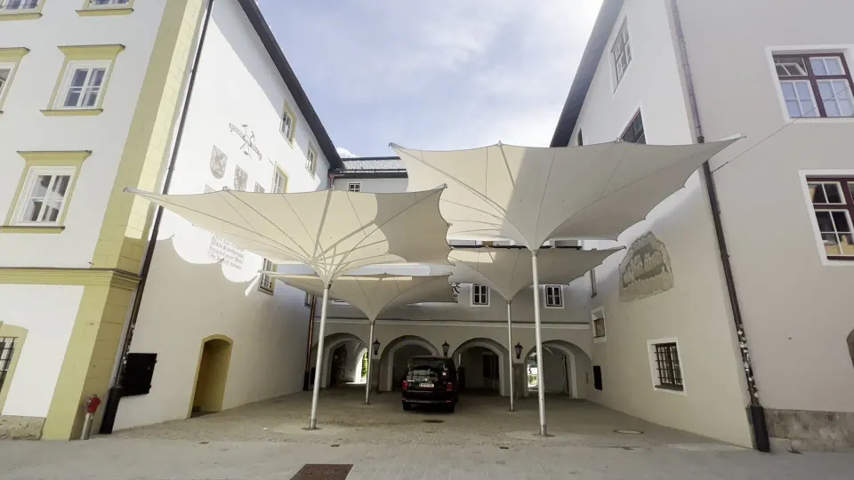 Verfahrbare Trichterschirme 7 × 7 m in einem historischen Innenhof, Kitzbühel
