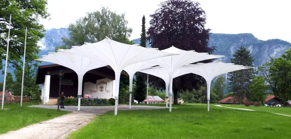 Weiße Trichterschirme in einem Park vor Bergen