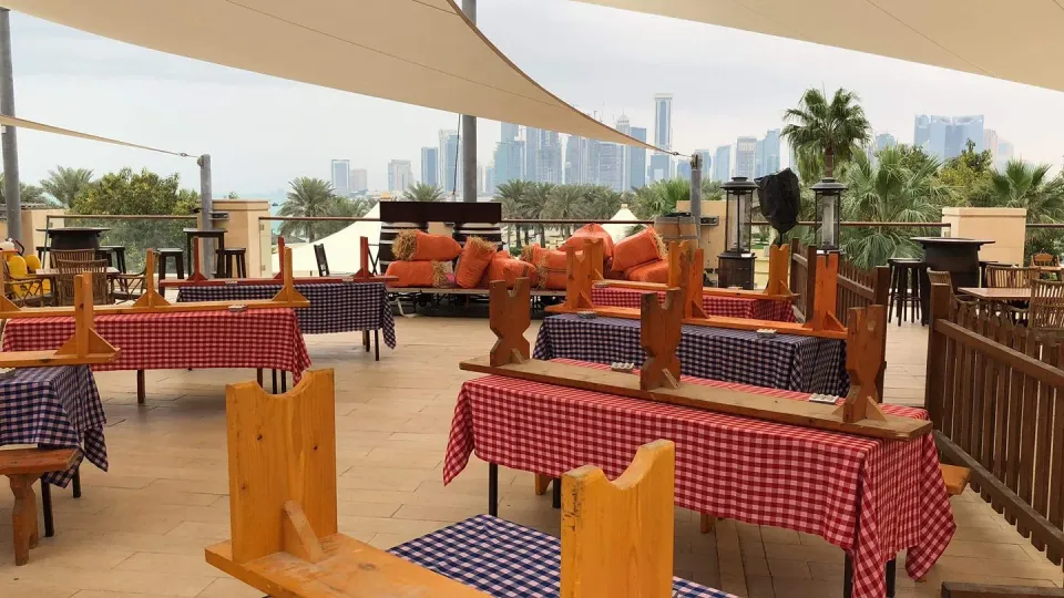 Ausgefahrenes Rollsegel über einer Restaurantterrasse, im Hintergrund Hochhäuser