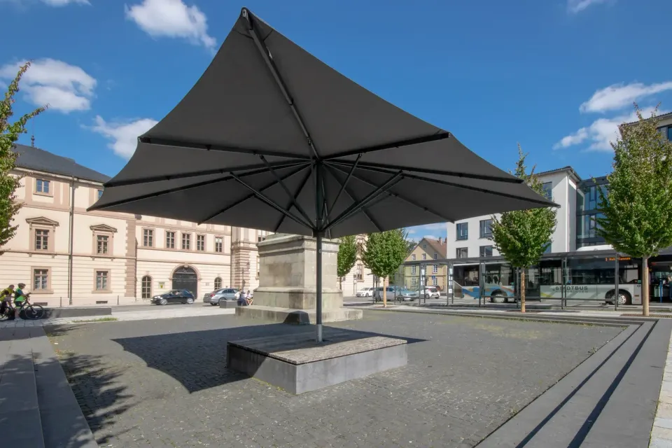 Großschirm über Sitzstufen auf einem städtischen Platz